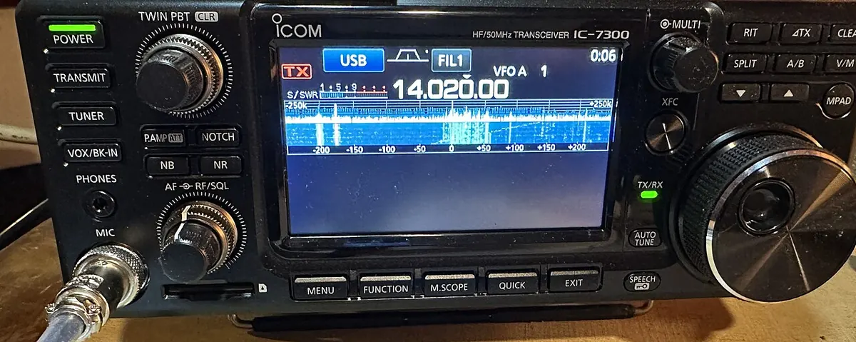 An ICOM IC-7300 transceiver tuned to 14.020 MHz, its blue waterfall display busy with Morse code contest signals